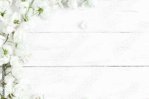 dog rose flowers on white wooden background  frame  top view  flat lay