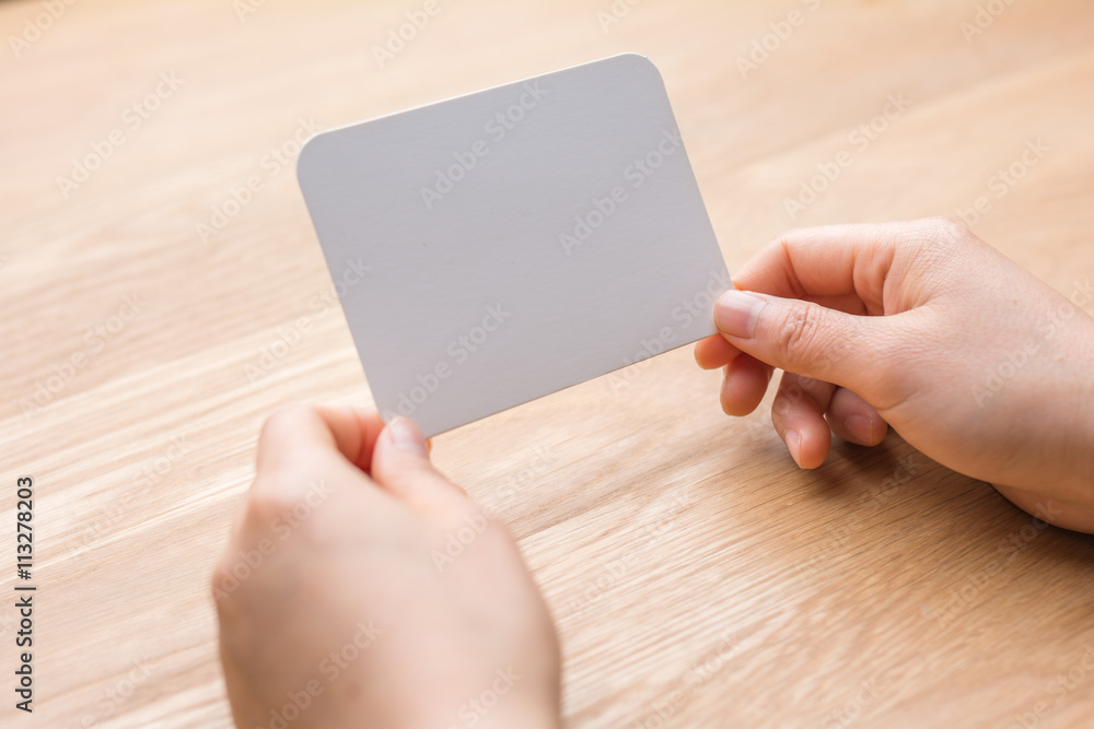 woman's hand holding white blank paper woman's hand holding white blank paper