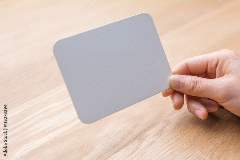 woman's hand holding white blank paper woman's hand holding white blank paper