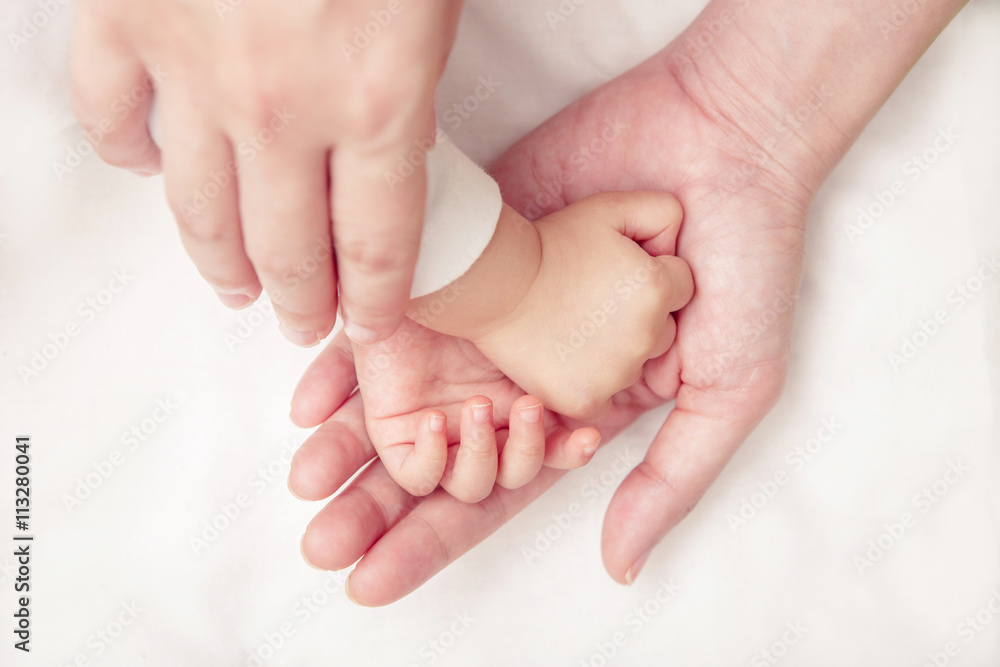 Baby hand gently holding adult's finger (Soft focus and blurry) Baby hand gently holding adult's finger (Soft focus and blurry)