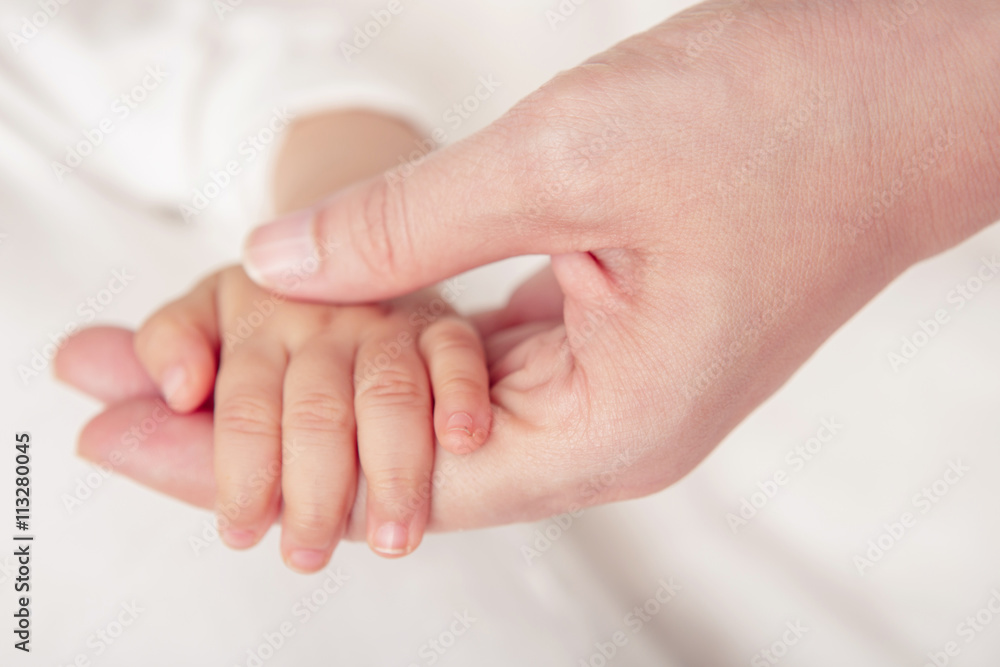 Baby hand gently holding adult's finger (Soft focus and blurry) Baby hand gently holding adult's finger (Soft focus and blurry)