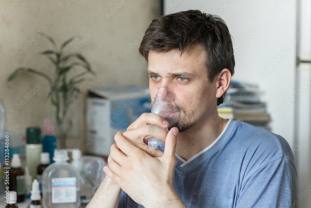 Man Inhaling Through Inhaler Mask Man Inhaling Through Inhaler Mask