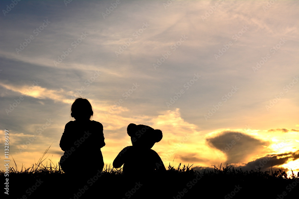 Silhouette a girl  with teddy bear on mountain and sky sunset
