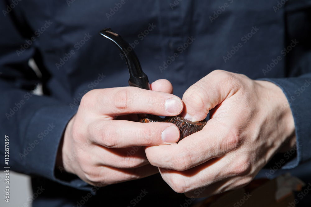 Fototapeta premium Unrecognizable young man with tobacco pipe