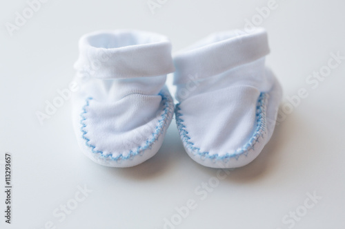 close up of white baby bootees for newborn boy