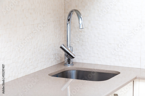 Tableau sur toile Kitchen stone counter with undermount build-in sink and mixer in a beige colors