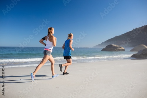 Fototapeta Naklejka Na Ścianę i Meble -  Friends jogging at the beach