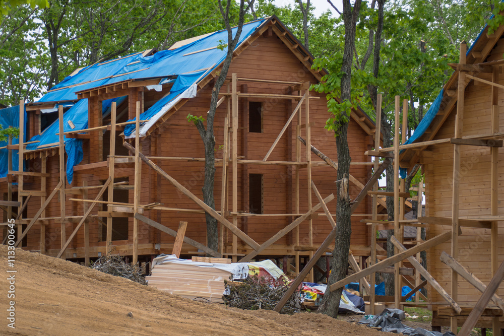 A big wooden house under construction, view from the left A big wooden house under construction, view from the left
