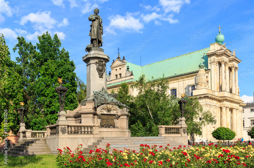 Naklejka premium Warszawa, pomnik Adama Mickiewicza na Krakowskim Przedmieściu. W tle Kościół Wizytek - styl barokowy