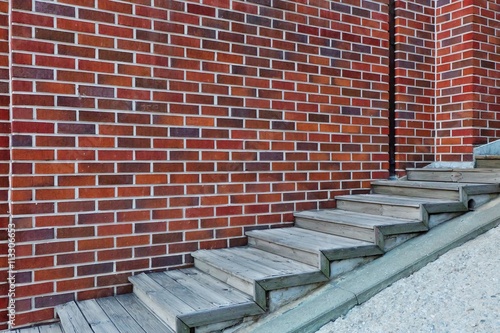 Wooden staircase with brick wall background.