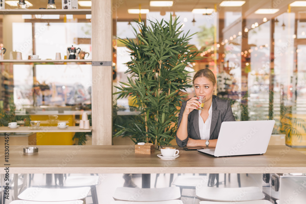 I love every minute of my job. Business woman working on laptop in cafeteria on her coffee break I love every minute of my job. Business woman working on laptop in cafeteria on her coffee break