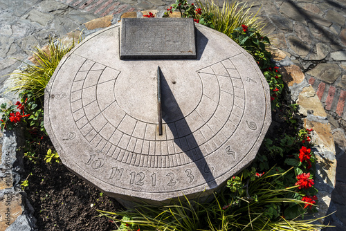 stone sundial with iron needle photo