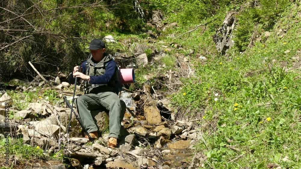 4K .Man tourist have rest near stream . Backpacker travel team 4K .Man tourist have rest near stream . Backpacker travel team