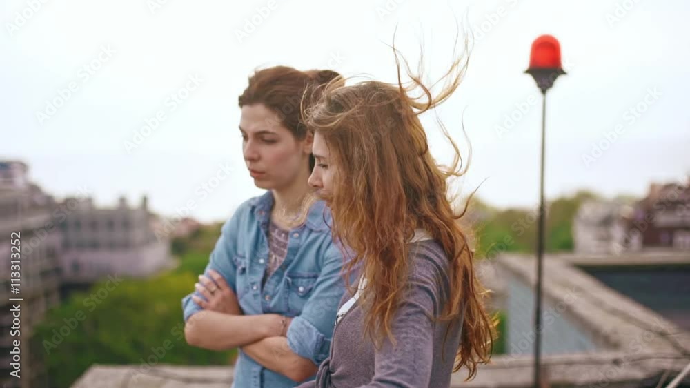 Two young beautiful women talking and laughing on the roof. Slow motion. Close up Two young beautiful women talking and laughing on the roof. Slow motion. Close up