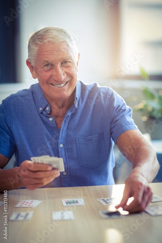 Senior man playing cards in living room