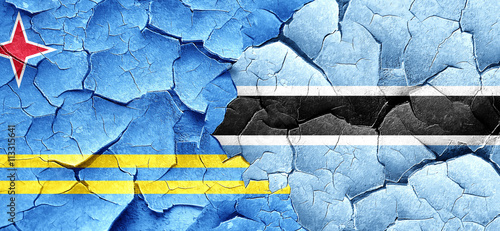 aruba flag with Botswana flag on a grunge cracked wall