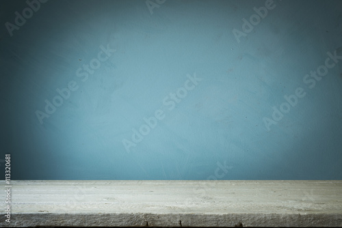 Background with wooden table and grunge blue wall photo