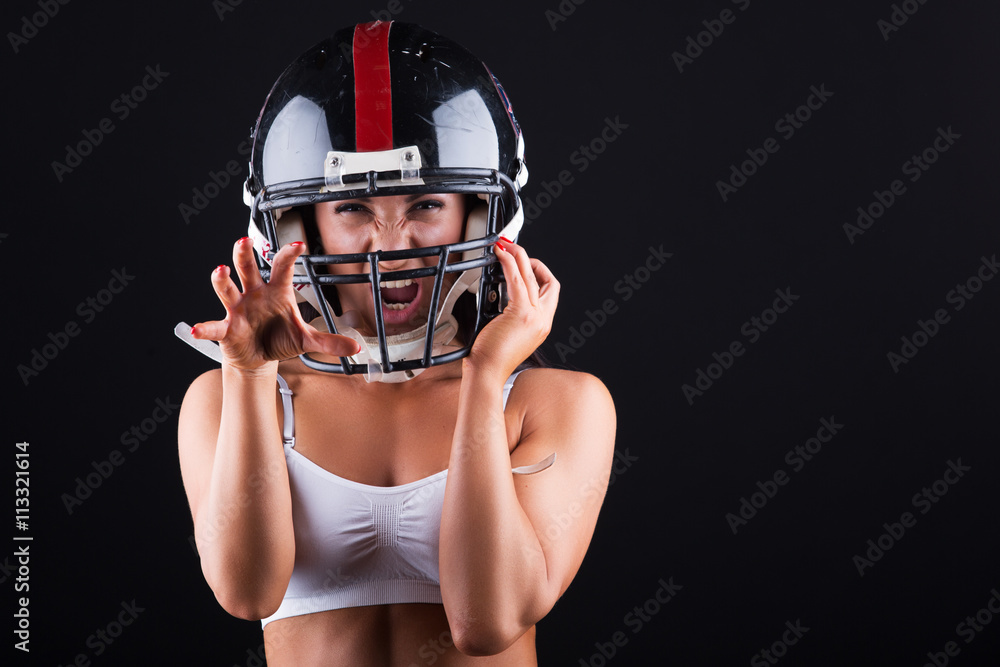 Young woman with football helmet and protection suit on a black