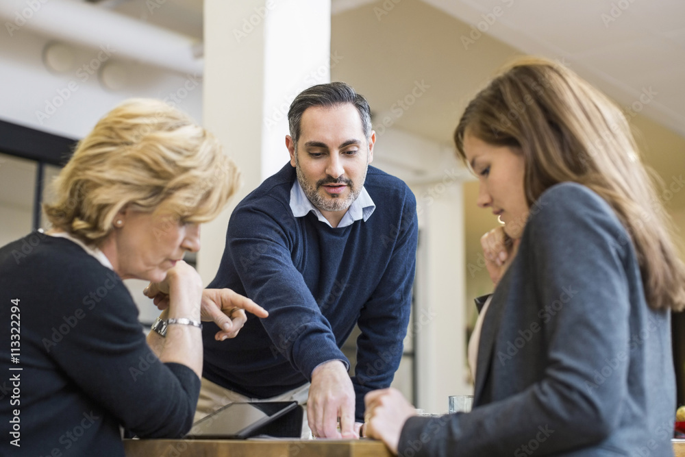Businessman talking with female colleagues in office meeting Businessman talking with female colleagues in office meeting