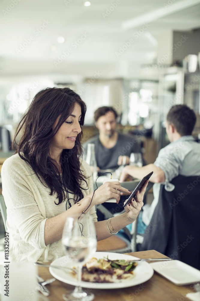 Businesswoman with mobile phone and digital tablet in restaurant Businesswoman with mobile phone and digital tablet in restaurant