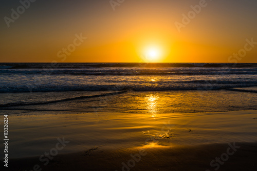 Beach of Pacific Ocean. Magnificent panorama of sunset over the ocean.