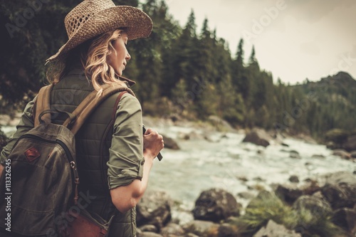 Foto Beautiful woman hiker enjoying amazing landscapes near wild mountain river