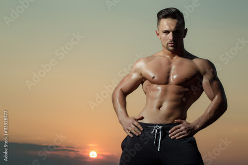 Sexy muscular man on sky background