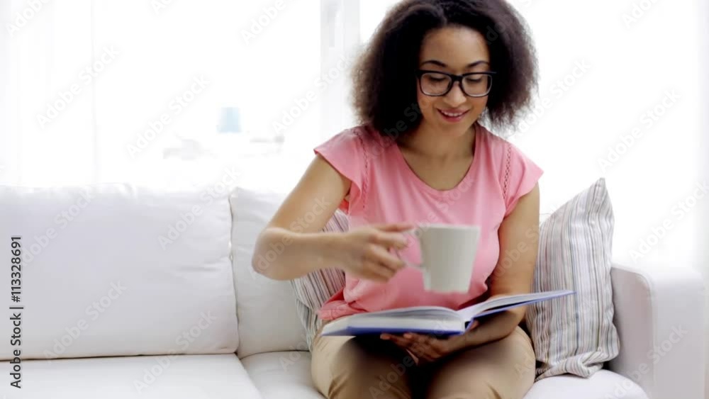 african woman reading book and drinking tea african woman reading book and drinking tea