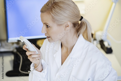 Female doctor using dictation device in office photo