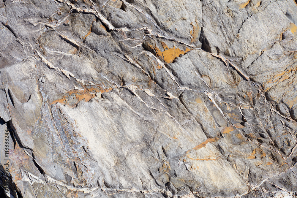 Uneven stone texture background with yellow lichen Uneven stone texture background with yellow lichen