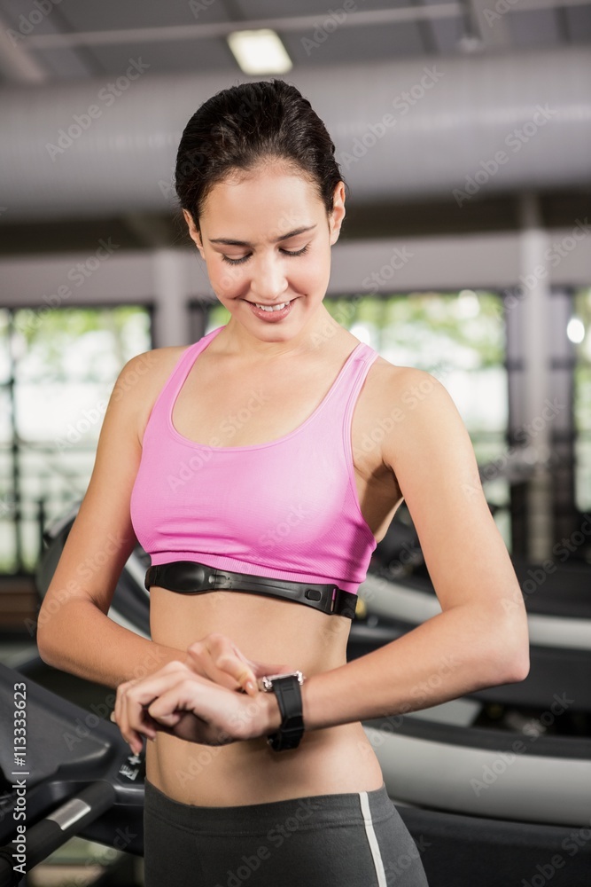Woman using smart watch on treadmill Woman using smart watch on treadmill