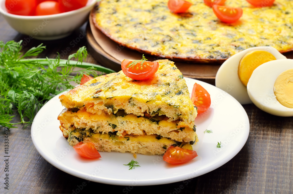 Homemade omelet with herbs and vegetables on wooden background,