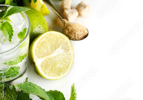 Ingredients for making mojitos (ice cubes, mint leaves, sugar and lime on white background)
