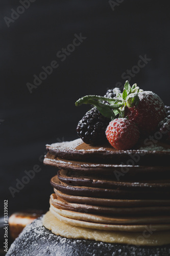 Billede på lærred Chocolate pancakes, strawberries, blackberries and castor sugar