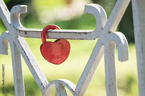 Red lock on fence of bridge