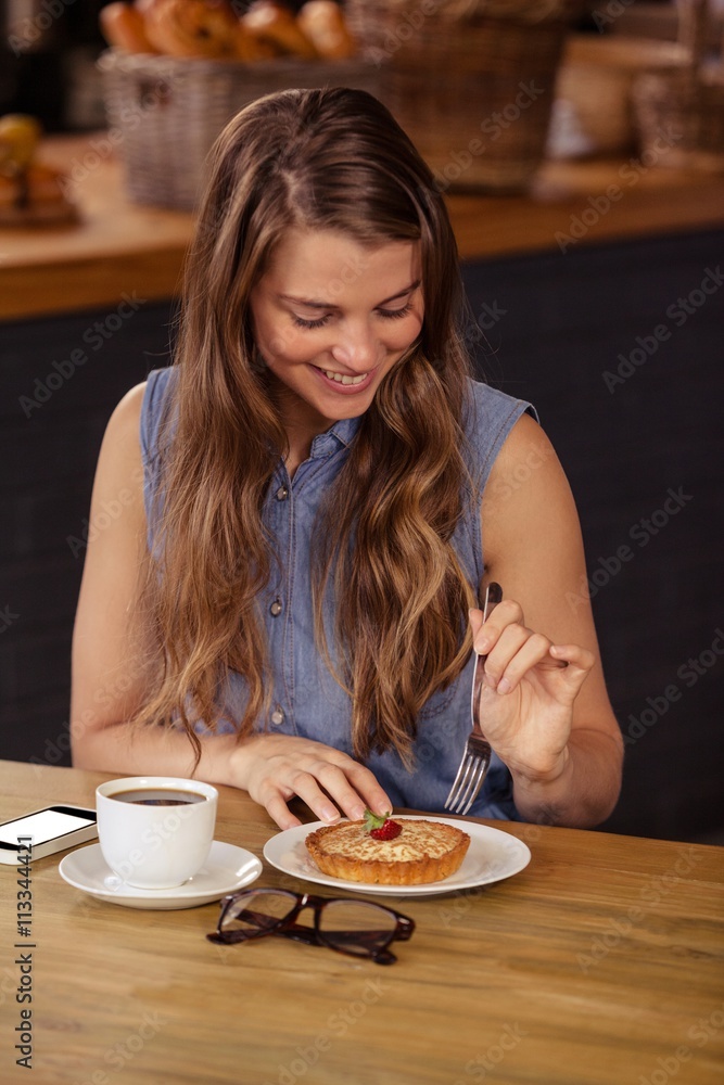 Portrait of smiling girl eating pastry