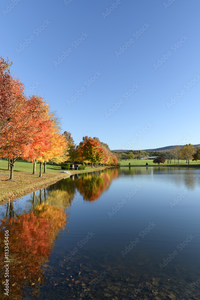 Lake in Autumn Surrounded by Trees in Fall Colors Lake in Autumn Surrounded by Trees in Fall Colors