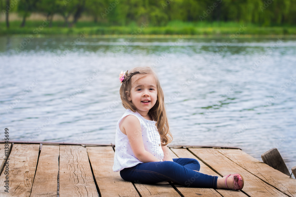 emotions of a little girl on beautiful wooden pier