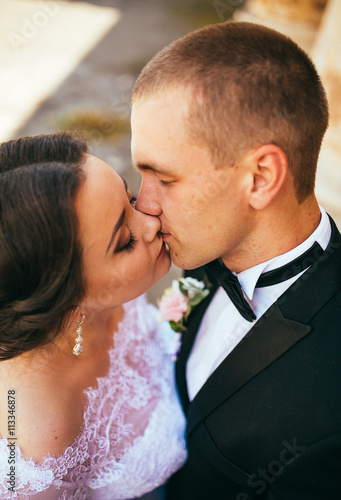 Beautiful bride and handsome groom at wedding day lovely hugging outdoors on nature. Bridal couple, happy newlywed woman and man embracing in green park. Loving wedding couple outdoor. Close up.