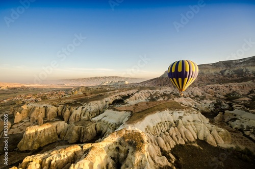 Hot air balloon flying over volcanic rock landscape, Cappadocia, Turkey