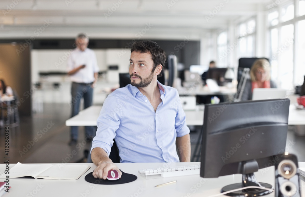 Businessman using computer while looking away Businessman using computer while looking away