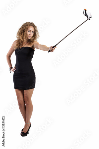 Young woman takes selfie with monopod