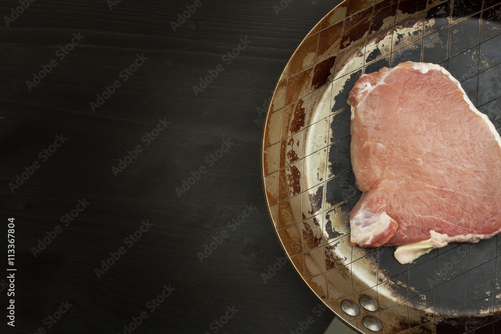 Foto de Raw pork on steel saucepans. Preparing barbecue pork steak. Sales of pork on the grill