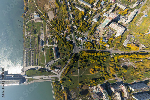 Aerial water power plant view with crossroads and roads, houses, buildings, parks and parking lots, bridges. Copter shot. Panoramic image.