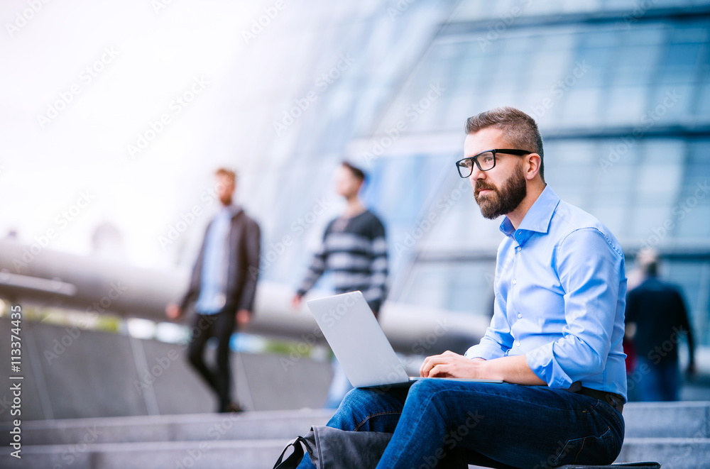 Manager with laptop, sitting on stairs, London, City Hall Manager with laptop, sitting on stairs, London, City Hall