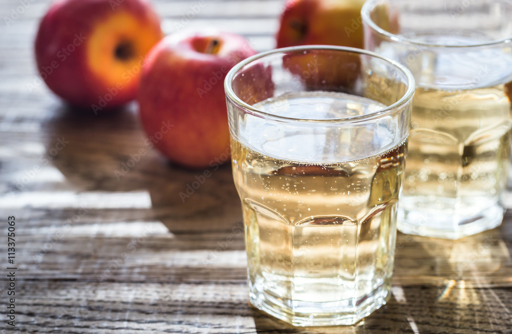 Two glasses of cider on the wooden background