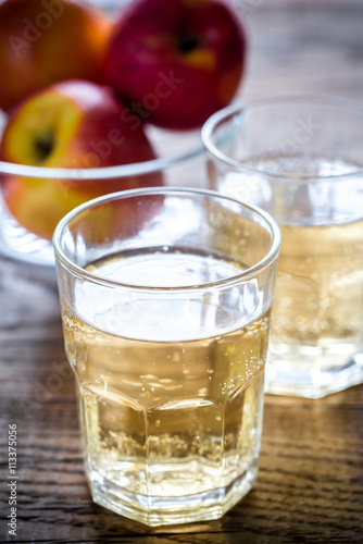 Two glasses of cider on the wooden background