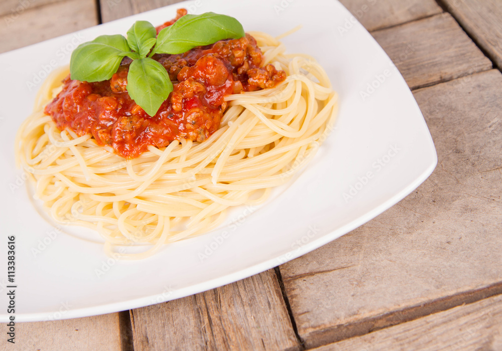 Spaghetti bolognese on a plate on a wooden background Spaghetti bolognese on a plate on a wooden background