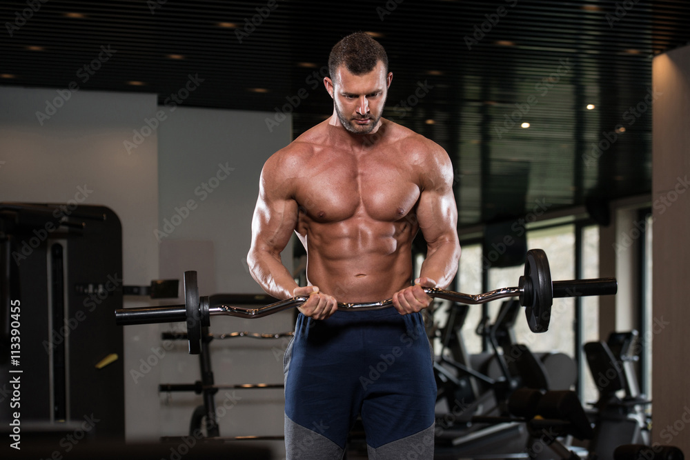 Muscular Man Exercising Biceps With Barbell