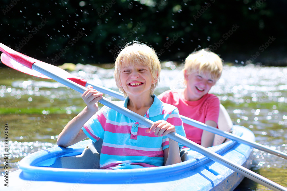 Two happy kids kayaking on the river. Active happy twin brothers ...